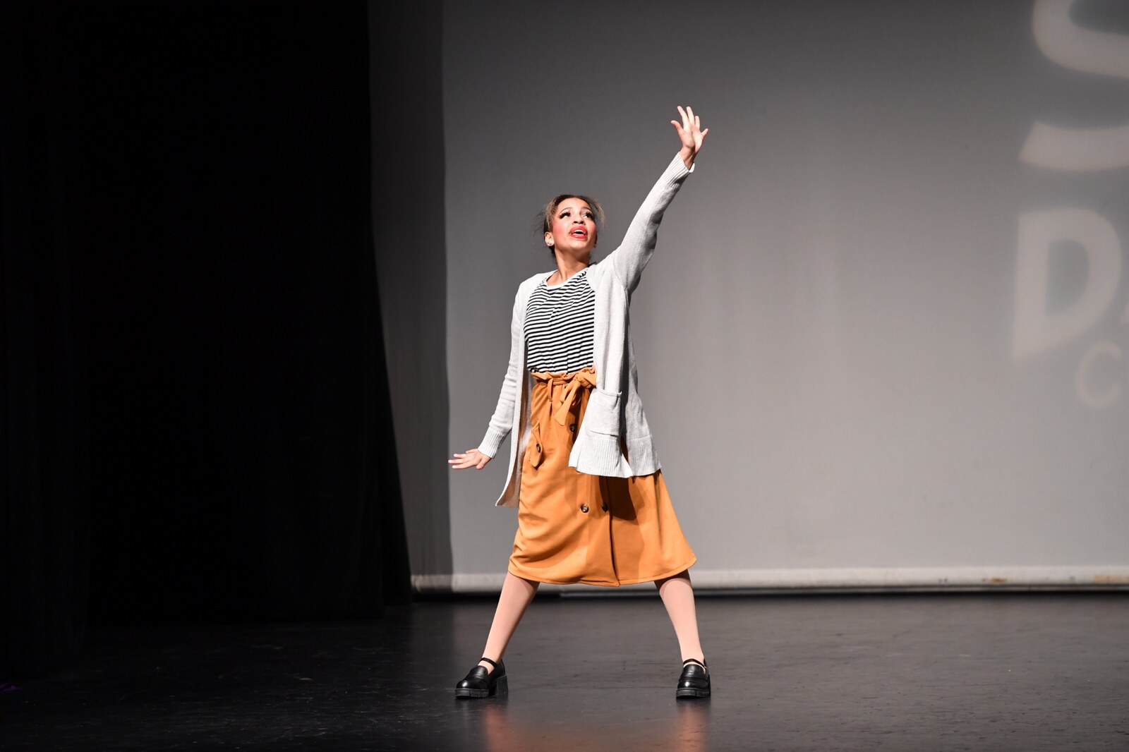 Ciara Rayne reaching upward during a stage performance